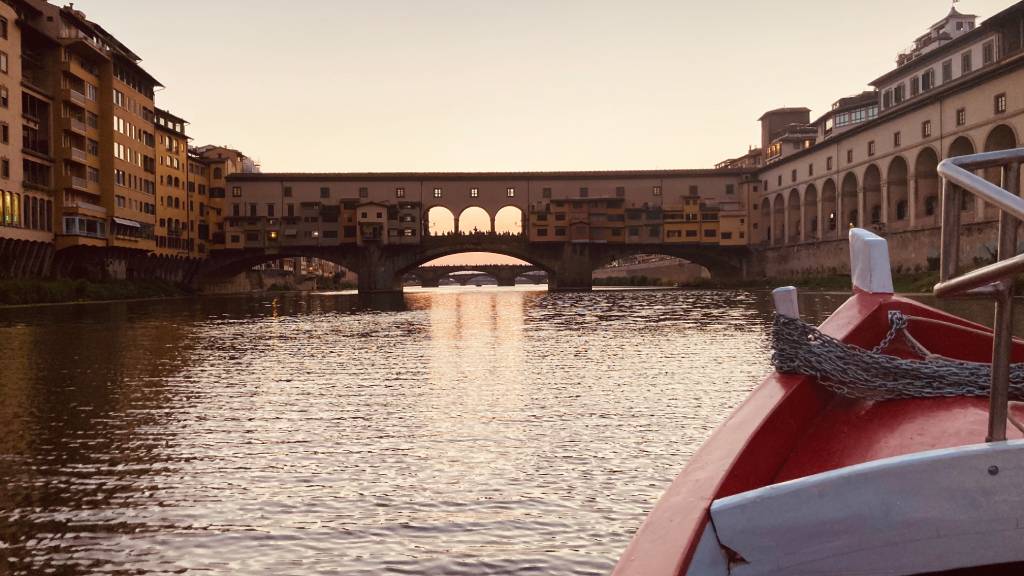 Tramonto Firenze. Sullo sfondo ponte Vecchio. in primo piano la barchetta sul fiume Arno